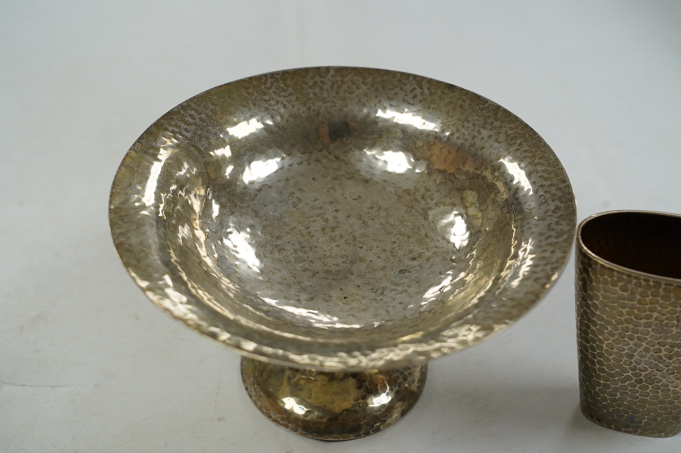 A George V Arts & Crafts planished silver bowl, on tripod supports and circular foot, Walker & Hall, Sheffield, 1912, diameter 15.7cm and a German planished vase inscribed 'Weihnachten 1897'. Condition - fair